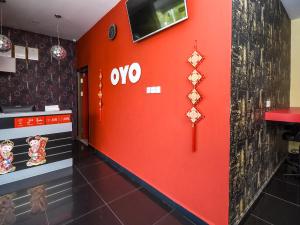 Una pared roja en un restaurante con un letrero en él en OYO 89301 Ys Inn, en Miri