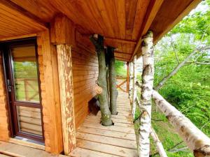 un porche de madera de una cabaña con árboles. en Rakhiv Plai, en Rakhiv