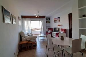 sala de estar con mesa y comedor en Apartamento en la Playa de Punta Umbría, en Punta Umbría