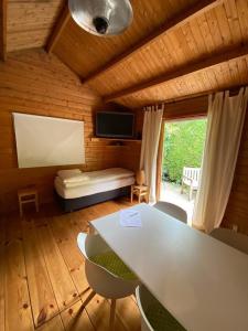 ein Wohnzimmer mit einem Tisch und Stühlen sowie einem TV in der Unterkunft La-Perchade in Huissen