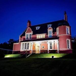 una gran casa de ladrillo rojo con luces en el césped en Glentower Lower Observatory, en Fort William