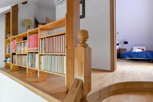 a living room with wooden bookshelves and a bedroom at Hmooyi Hill Cottage in Kolarovec