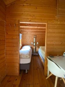 a log cabin bedroom with a bed and a tub at La-Perchade in Huissen