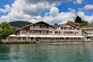 a hotel on the water next to a body of water at Strandhotel Seeblick in Faulensee