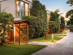 a house with a gazebo in the grass at Rixos Premium Belek - The Land of Legends Access in Belek
