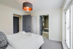 a white bedroom with a bed and a bathroom at Tailored Stays - Lovell Lodge in Cambridge