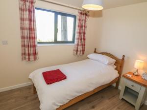 Un dormitorio con una cama con una toalla roja. en Glan Yr Afon, en Holyhead