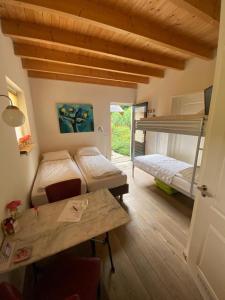 Zimmer mit 2 Etagenbetten, einem Tisch und einem Schreibtisch in der Unterkunft La-Perchade in Huissen