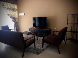 a living room with a couch and a tv at DV Villa @ Angsana Sari in Sungai Petani