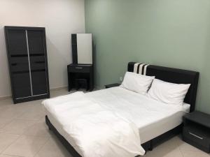 una camera da letto con un letto con lenzuola bianche e uno specchio di DV Villa @ Angsana Sari a Sungai Petani