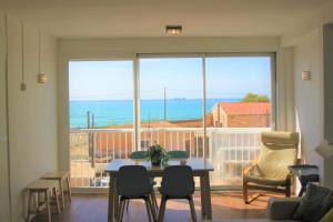 ein Wohnzimmer mit einem Tisch und Stühlen sowie einem großen Fenster in der Unterkunft City Sea Views Apartment Alicante in Alicante