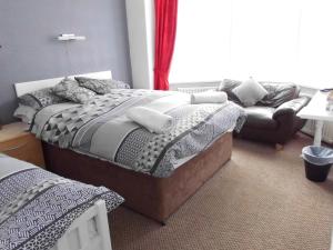 um quarto com uma cama e um sofá em Jasmine Guest House em Bridlington