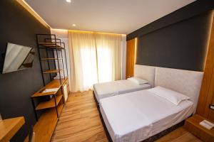 a bedroom with two beds and a book shelf at Inada Hotel Ksamil in Ksamil