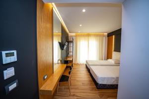 a hotel room with two beds and a mirror at Inada Hotel Ksamil in Ksamil