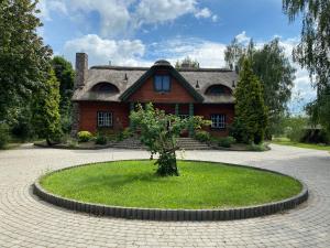 une maison avec un arbre au milieu d'un cercle dans l'établissement Szczęśliwisko, à Różanów