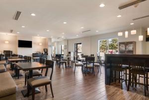 a restaurant with tables and chairs and a bar at Sleep Inn East Camden in Camden