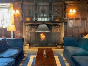 a living room with a fireplace and a couch and a table at Mortons Manor in Corfe Castle