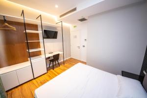 a bedroom with a bed and a desk at Inada Hotel Ksamil in Ksamil