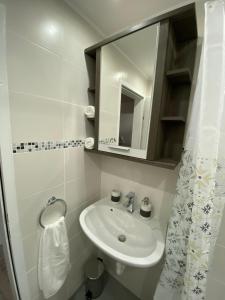 ein weißes Badezimmer mit Waschbecken und Spiegel in der Unterkunft Ossiach Apartment 1 in Heiligen Gestade + 25 Fotos