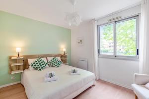 - une chambre avec un lit blanc et une fenêtre dans l'établissement Beautiful 1-bedroom w balcony and garden near Lyons city center Welkeys, à Caluire-et-Cuire