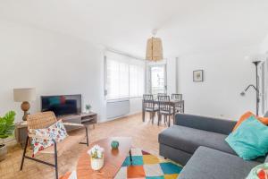 ein Wohnzimmer mit Sofa und Tisch in der Unterkunft Appartement Mansana - Welkeys in Caluire-et-Cuire