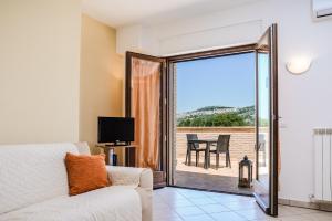 a living room with a couch and a sliding glass door at Residenza Il Rivo in Rivotorto