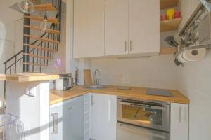 uma cozinha com armários brancos e um balcão de madeira em Duplex with terrace nearby the beach of Cabourg Welkeys em Cabourg