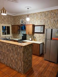 a kitchen with a refrigerator and a counter top at Villa Ar Rayis Beach in Rayyis