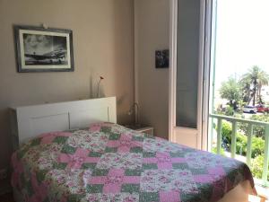 a bedroom with a bed with a quilt on it at L'ilot Fleuri in Le Lavandou