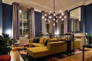 a living room with a yellow couch and blue walls at Staybridge Suites The Hague - Parliament, an IHG Hotel in The Hague