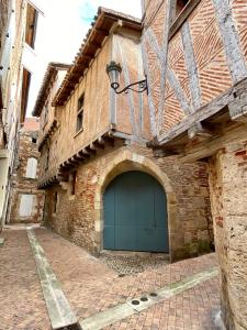 a large brick building with a blue garage at Le Bistrot - Au Coeur d'Agen - Self Checkin - Wifi - Netflix - Smart TV - Luqs fr in Agen