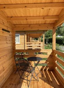 a wooden cabin with a table and a chair in it at Camping Piccolo Paradiso in Avegno