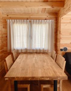 a dining room with a wooden table and a window at Camping Piccolo Paradiso in Avegno