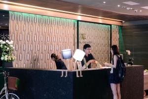 a man and a woman standing at a counter at Kiwi Express Hotel - Jiuru Rd in Kaohsiung