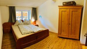 een slaapkamer met een bed, een dressoir en een raam bij Ferienwohnung Zur Staffenbrugg in Kössen