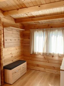 a log cabin with a bench and a window at Camping Piccolo Paradiso in Avegno