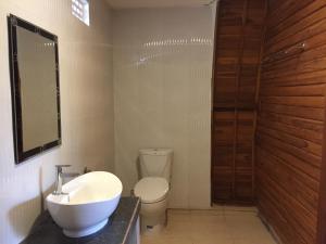 uma casa de banho com um lavatório branco e um WC. em Druwa Bali em Uluwatu