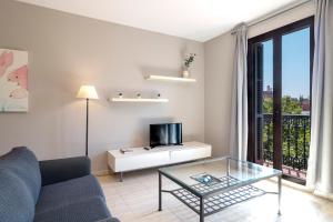 een woonkamer met een bank en een tv bij Stay U-nique Apartments Gran Via II in Barcelona