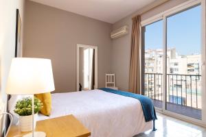 een slaapkamer met een bed en een groot raam bij Stay U-nique Apartments Gran Via II in Barcelona