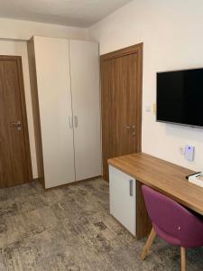 Una habitación con un escritorio y un televisor en la pared. en Hotel Villa Barbara, en Neum