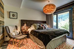 Un dormitorio con una cama grande y una silla. en Peace and Love, en Chamonix-Mont-Blanc