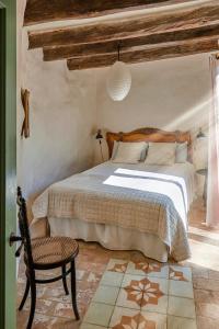 1 dormitorio con 1 cama y 1 silla en Casa La Premsa at Masia Nur Sitges, Adults only, en Canyelles