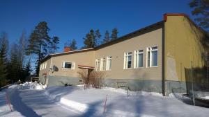 a house with snow in front of it at Wanha Havon Koulu yksiö in Savitaipale