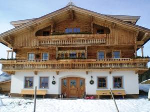 ein großes Holzhaus im Schnee in der Unterkunft Apartement Vorderlaiming in Söll