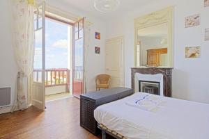 昂代Appartement Mimosas - 3 étoiles - Welkeys的一间卧室配有一张带壁炉和镜子的床