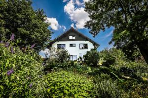 a white house in the middle of a garden at Villa Kakelbont Borgloon in Borgloon