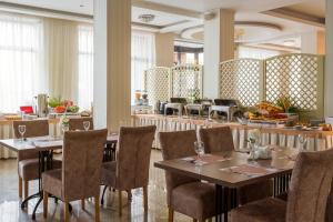 una sala da pranzo con tavoli e sedie e un ristorante di Arcadia Hotel a Odessa