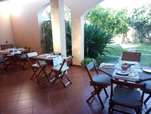 a dining room with tables and chairs and a patio at West Coast in Càbras