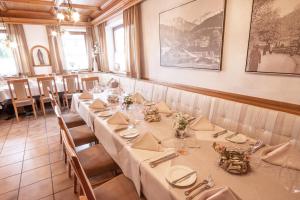 uma sala de jantar com mesas longas com toalhas de mesa brancas em Hotel & Gasthaus Dresch em Erl