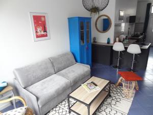 a living room with a couch and a kitchen at Studio L'AZULEJOS in Le Havre